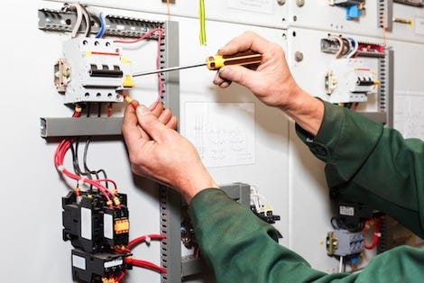 Electrician working on switchboard panel
